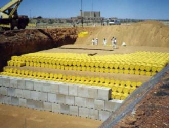 Fusti contenenti materiale radioattivo pronti per essere sotterrati